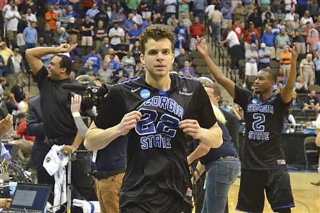 Georgia State's R.J. Hunter (22) comes off the court after making a game winning shot against Baylor, as head coach Ron Hunter, back left, and Ryann Green (2) celebrate their 57-56 in the second round of the NCAA college basketball tournament, Thursday, March 19, 2015, in Jacksonville, Fla. (AP Photo/Rick Wilson)