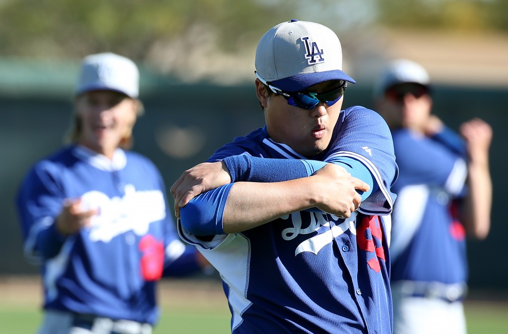 Ryu Hyun-jin stretches his shoulder on Sunday, but could not throw without discomfort. (Yonhap)