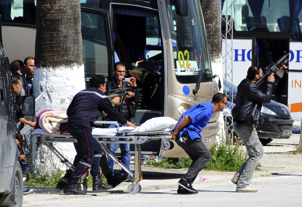 Escorted by security forces, rescue workers pull an empty stretcher outside the Bardo museum Wednesday, March 18, 2015 in Tunis, Tunisia. Authorities say scores of people are dead after an attack on a major museum in the Tunisian capital, and some of the gunmen may have escaped. (AP Photo/Salah Ben Mahmoud)