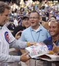 FILE - In this July 18, 2012, file photo, comedian Will Ferrell, left, talks with fans after throwing out the ceremonial first pitch before a baseball game between the Miami Marlins and the Chicago Cubs in Chicago. Ferrell will appear in at least two Arizona spring training games on Thursday, March 12, 2015. The Chicago White Sox confirmed the star of "Anchorman" and many other movies will appear in their game against the San Francisco Giants in Glendale and the San Diego Padres say he will play in their game against the Los Angeles Dodgers in Peoria. (AP Photo/Nam Y. Huh, File)