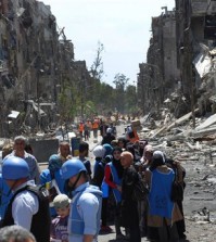 FILE - This picture taken on Thursday, April. 24, 2014 and provided by the United Nations Relief and Works Agency for Palestine Refugees in the Near East (UNRWA), U.N relief workers with blue helmets and vests stand next of residents of the besieged Palestinian camp of Yarmouk, right, who stand in line to receive aid food distributed by UNRWA, on the southern edge of the Syrian capital Damascus, Syria. On wednesday, April. 1, 2015 Islamic State militants infiltrated the Palestinian refugee camp of Yarmouk in the Syrian capital marking the deepest foray yet by the extremist group into Damascus, seat of President Bashar Assads power, Syrian opposition activists and Palestinian officials said. (AP Photo/UNRWA, File )