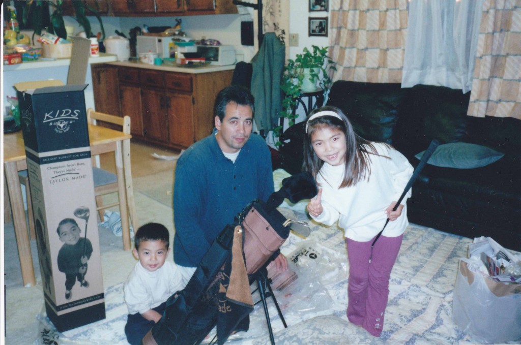 Alison receives a brand new set of clubs from her father and her brother shares in the excitement. (Courtesy of Alison Lee)