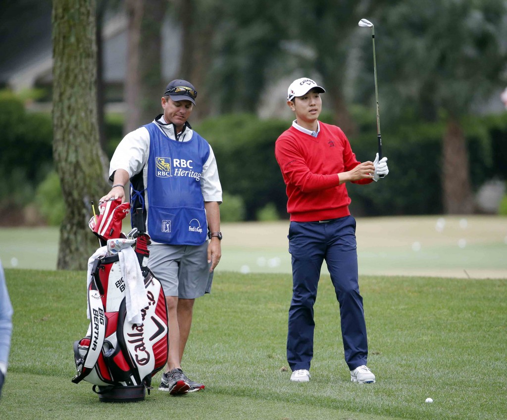 Sang-Moon Bae, right, of South Korea, prepares to hit on the ninth fairway during the first round of the RBC Heritage golf tournament in Hilton Head Island, S.C., Thursday, April 16, 2015. (AP Photo/Stephen B. Morton)