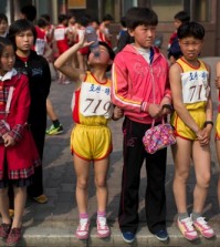 Young North Korean runners rest after finishing their part of the Mangyongdae Prize International Marathon in 2014. (David Guttenfelder/AP)