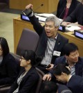 A North Korean defector, center, yells to try and drown out a statement being read by North Korean diplomats during a panel on North Korean human rights abuses, at United Nations headquarters, Thursday, April 30, 2015. (AP Photo/Seth Wenig)