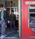 Jason Park, left, and his friend business owner Sung Kang, second left, leave his damaged store, Tuesday, April 28, 2015, in the aftermath of rioting following Monday's funeral for Freddie Gray, who died in police custody. The violence that started in West Baltimore on Monday afternoon had spread to East Baltimore and neighborhoods close to downtown and near Camden Yards.  (AP Photo/Matt Rourke)