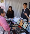 Korea Foundation Head Kim Byung-gon, second from left, helps introduce Korean literature to a book fair attendee at the Los Angeles Times Festival of Books. (Lee Woo-su/Korea Times)