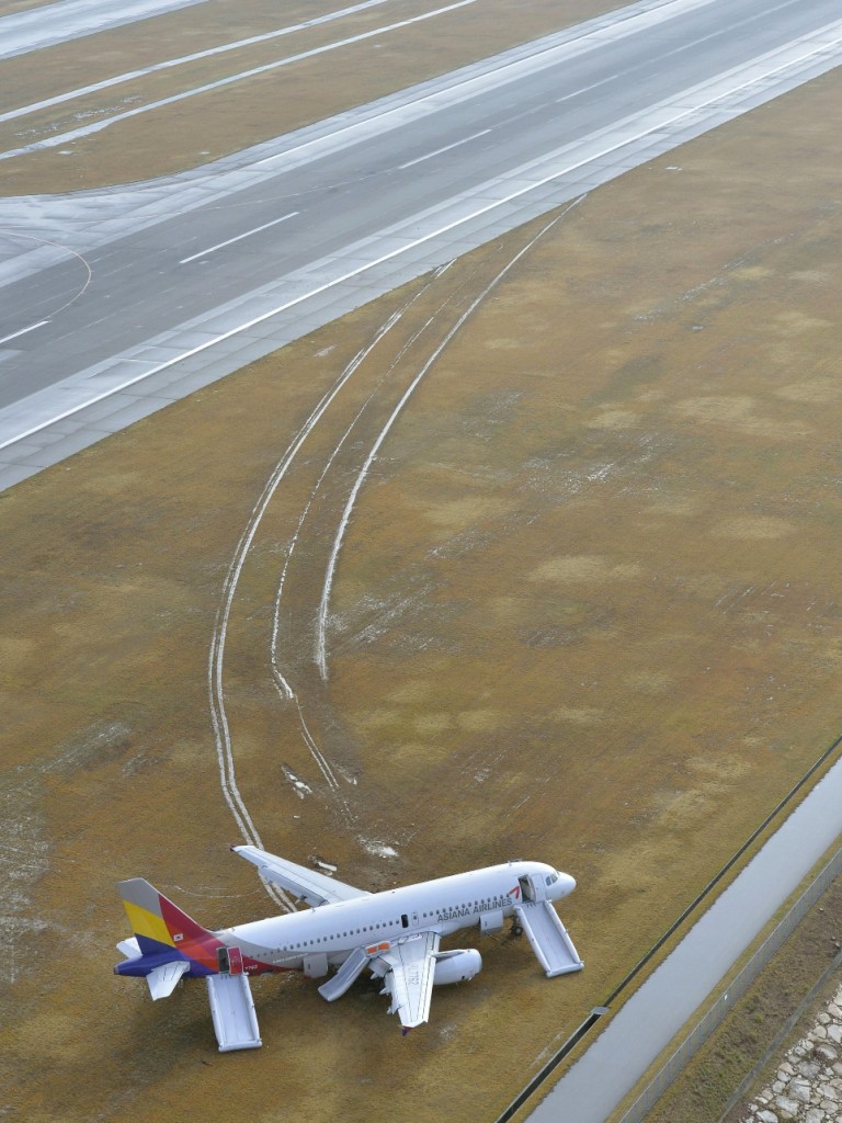 An Asiana Airlines plane sits at Hiroshima airport in Mihara, Hiroshima prefecture, western Japan Wednesday, April 15, 2015 after it skidded off a runway Tuesday. About 20 people received minor injuries, officials said. (Muneyuki Tomari/Kyodo News via AP)