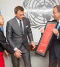 In this photo provided by the United Nations, U.N. Secretary General Ban Ki-moon, right, presents actor Daniel Craig, center, with a document designating him as the UN Global Advocate for the Elimination of Mines and Explosive Hazards, at United Nations headquarters, Tuesday, April 14, 2015. At left is Agnès Marcaillou, Director of the UN Mine Action Service. (Evan Schneider/The United Nations via AP)