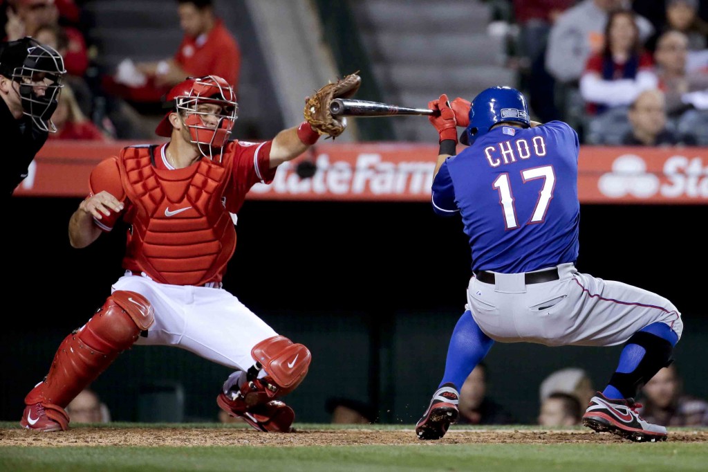 Texas Rangers' Choo Shin-soo gets out of the way of a pitch as Los Angeles Angels catcher Drew Butera catches the ball during the sixth inning of a baseball game in Anaheim, Calif., Saturday, April 25, 2015. (AP Photo/Chris Carlson)