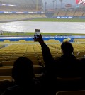 A fan takes a picture during a rain delay prior to a baseball game between the Los Angeles Dodgers and the San Diego Padres, Tuesday, April 7, 2015, in Los Angeles. (AP Photo/Mark J. Terrill)