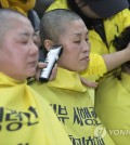 Family members of the victims of the April 2014 ferry disaster that claimed more than 300 lives have their heads shaved at Gwanghwamun Square in downtown Seoul on April 2, 2015, to demand the vessel's recovery and the truth behind the accident before the discussion of compensation measures for the families. (Yonhap)