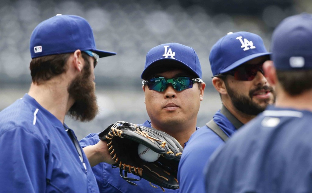 Los Angeles Dodgers starting pitcher Hyun-Jin Ryu, center, gets a ball from Los Angeles Dodgers' Scott Van Slyke, left, during warmups prior to a baseball game against the San Diego Padres, Saturday, April 25, 2015, in San Diego. (AP Photo/Lenny Ignelzi))