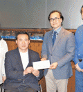 Tony Choe, second from left, hands a donation to Korean American Scholarship Foundation leaders.