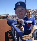 FILE - In this March 15, 2015, file photo, Brooke Schneider, a Los Angeles Dodgers fan from Thousand Oaks, Calif., is on the rail attempting to get the attention of starting pitcher Clayton Kershaw during a spring training baseball game against the Seattle Mariners in Peoria, Ariz. With Derek Jeter gone, who will reign as the face of the majors? Could be Clayton Kershaw. (AP Photo/Lenny Ignelzi, File)