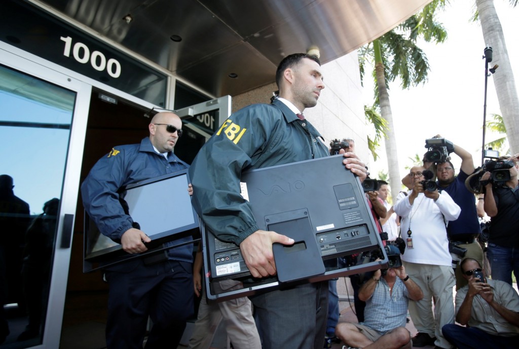 Federal agents load a van with boxes and computers taken from the headquarters of the Confederation of North, Central America and Caribbean Association Football (CONCACAF,) Wednesday, May 27, 2015, in Miami Beach, Fla. Swiss prosecutors opened criminal proceedings into FIFA's awarding of the 2018 and 2022 World Cups, only hours after seven soccer officials were arrested Wednesday pending extradition to the U.S. in a separate probe of "rampant, systemic, and deep-rooted" corruption. (AP Photo/Wilfredo Lee)
