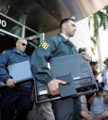 Federal agents load a van with boxes and computers taken from the headquarters of the Confederation of North, Central America and Caribbean Association Football (CONCACAF,) Wednesday, May 27, 2015, in Miami Beach, Fla. Swiss prosecutors opened criminal proceedings into FIFA's awarding of the 2018 and 2022 World Cups, only hours after seven soccer officials were arrested Wednesday pending extradition to the U.S. in a separate probe of "rampant, systemic, and deep-rooted" corruption. (AP Photo/Wilfredo Lee)