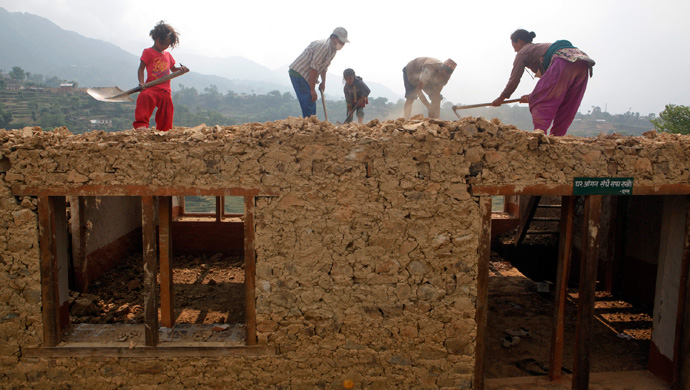 A Nepalese family works to rebuild their damaged house in Lalitpur, Nepal, Friday, May 8, 2015. The April 25 earthquake killed thousands and injured many more as it flattened mountain villages and destroyed buildings and archaeological sites in Kathmandu. (AP Photo/Niranjan Shrestha)