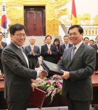 South Korean Trade, Industry and Energy Minister Yoon Sang-jik (L) and his Vietnamese counterpart, Vu Huy Hoang, shake hands after signing a bilateral free trade agreement in Hanoi on May 5, 2015. The two countries seek to implement the deal by the year`s end. (Yonhap)