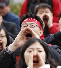 Union members of Korea Exchange Bank shout slogans during a rally in front of Financial Services Commission in Seoul, South Korea, Friday, Nov. 18, 2011. The Korean read "Defend, Foreign Exchange Bank." (AP Photo/Lee Jin-man)