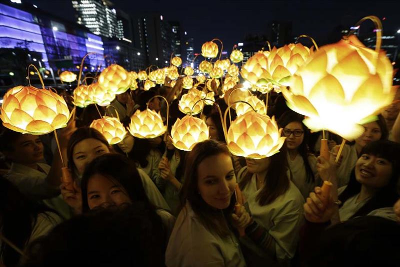 Buddhist believers holding lanterns in the shape of lotus flowers walk around the Gwanghwamun Plaza to celebrate upcoming Buddha's birthday on May 25 in Seoul, South Korea. (AP Photo/Ahn Young-joon)
