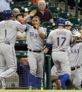 Texas Rangers'  Shin-Soo Choo (17) and Elvis Andrus (1) are congratulated as they score in the first inning on a double by Prince Fielder in a baseball game Tuesday May 5, 2015 in Houston. (AP Photo/Bob Levey)