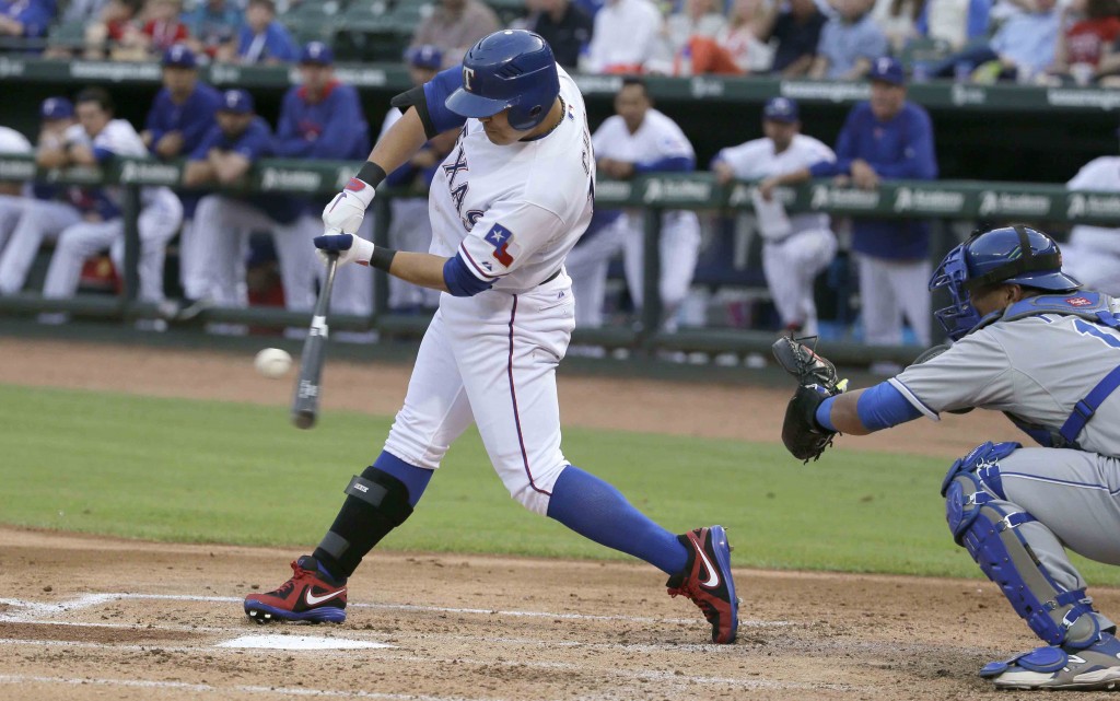 Texas Rangers Shin-Soo Choo, of South Korea, left, hits an RBI single in front of Kansas City Royals catcher Salvador Perez during the second inning of a baseball game in Arlington, Texas, Monday, May 11, 2015. Rangers Delino DeShields scored on the play. (AP Photo/LM Otero)