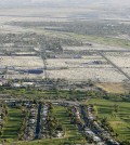 In this April 3, 2015 aerial file photo, lush green golf courses border the edge of the desert in Palm Springs, Calif. Pressed by the fourth year of bone-dry weather and the threat of state-mandated water cuts, some of the poshest courses in California are ceding back to nature some of their manicured green, installing high-tech moisture monitoring systems and letting the turf they don't rip up turn just a little bit brown. (AP Photo/Chris Carlson)