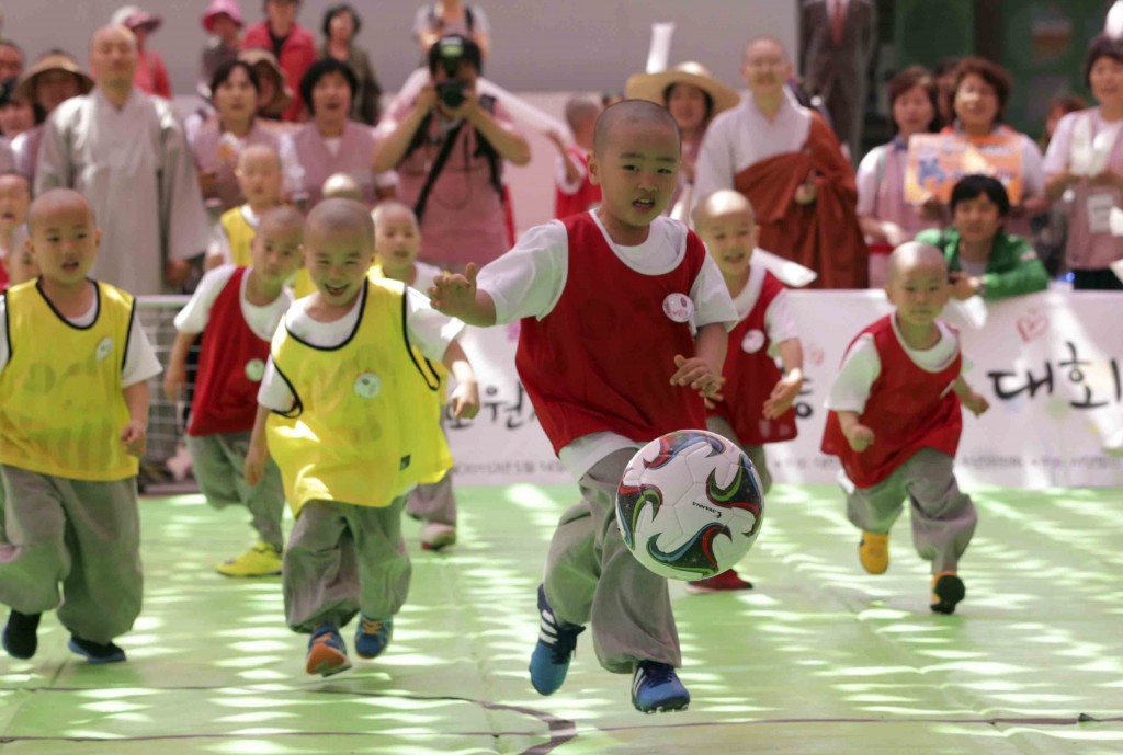 Shaven-headed children who entered temples to have an experience of monks' life for weeks, play Dongjasung (little monk) soccer at Jogye temple in Seoul, South Korea, Thursday, May 14, 2015. The Dongjasung soccer match is one of the events to celebrate Buddha's upcoming 2,559th birthday on May 25 and to publicize Korean Buddhism. (AP Photo/Lee Jin-man)