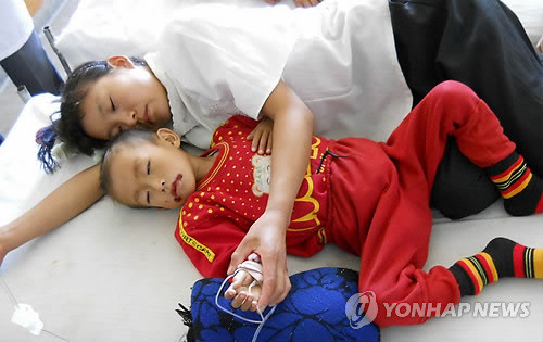 A North Korean mother comforts her ailing son. (Yonhap)