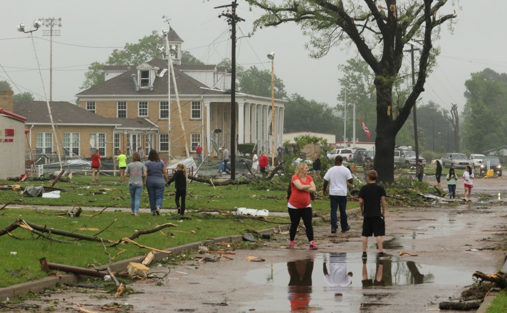 Dozens of Van, Texas, residents walk around the intermediate and elementary schools campuses as they survey the damage from Monday, May 11, 2015 severe weather that moved through the area in the early morning hours. Emergency responders searched through splintered wreckage Monday after a line of tornadoes battered several small communities in Texas and Arkansas, killing at least five people. (AP Photos/Todd Yates)