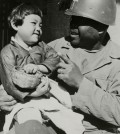 A military chaplain holds a young child in this photo taken by the International Committee of the Red Cross (ICRC) during the 1950-53 Korean War. The ICRC's Regional Delegation for East Asia released photos that provide a rare glimpse of the tragedy, Tuesday, to mark the 65th anniversary of the outbreak of the war. (Yonhap)