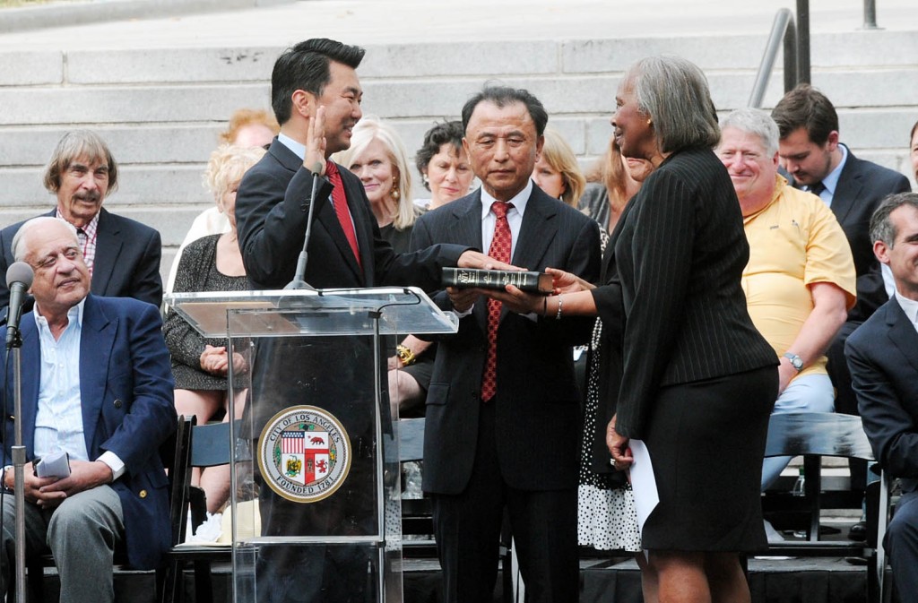 David Ryu, left, was sworn in Sunday in the south lawn of Los Angeles City Hall by County Supervisor Yvonne B. Burke, right. Center: Ryu Eul-joon, his father. (Park Sang-hyuk/Korea Times)