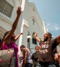 Rev. Jacqueline J. Lewis, left, of the Middle Collegiate Church in New York City and Muhiyidin D'Baha, right, of Black Lives Matter Charleston leads those in attendance in a song at the memorial in front of the Emanuel AME Church, Friday, June 19, 2015 in Charleston, S.C. (AP Photo/Stephen B. Morton)