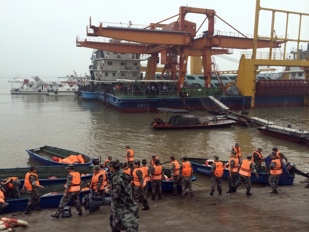 Rescue workers prepare to head out on boats on the Yangtze River to search for missing passengers after a ship capsized in central China's Hubei province Tuesday, June 2, 2015. The passenger ship carrying more than 450 people sank overnight in the Yangtze River during a storm in southern China, the official Xinhua News Agency reported Tuesday. (Chinatopix Via AP)
