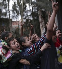 In this Nov. 5, 2014 photo, Egyptian children push each other as a woman takes a photograph of them with her mobile phone on the outskirts of the town of Aga., Egypt. Minister of State for Population Hala Youssef told The Associated Press on Tuesday, June 9, 2015, that the government is providing financial incentives to keep children in school, expanding family planning services and boosting public awareness. The Egyptian government aims to reduce the country's surging fertility rate to 2.4 over the next 15 years, from its current rate of 3.5. (AP Photo/Nariman El-Mofty)