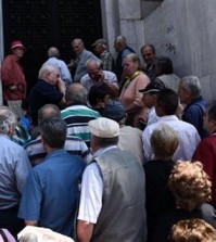 Elderly people, who usually get their pensions at the end of the month, wait outside a closed bank in the northern Greek port city of Thessaloniki, Monday, June 29, 2015. Greece's five-year financial crisis took its most dramatic turn yet, with the cabinet deciding that Greek banks would remain shut for six business days and restrictions would be imposed on cash machine withdrawals. (AP Photo/Giannis Papanikos)
