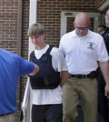 Charleston, S.C., shooting suspect Dylann Storm Roof, center, is escorted from the Shelby Police Department in Shelby, N.C., Thursday, June 18, 2015. Roof is a suspect in the shooting of several people Wednesday night at the historic The Emanuel African Methodist Episcopal Church in Charleston, S.C. (AP Photo/Chuck Burton)
