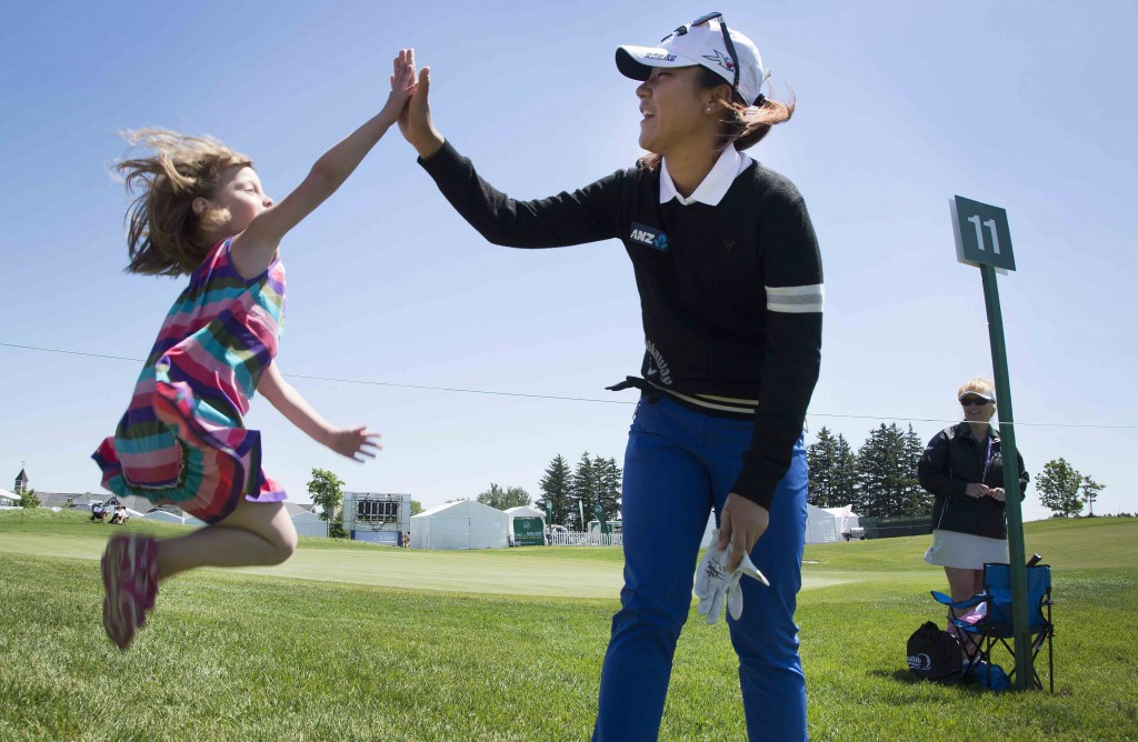 Lydia Ko, of New Zealand, gives a high-five to an enthusiastic young fan, four-year old Mackenzie Wilson after walking off the 11th hole during the pro-am at the Manulife LPGA Classic golf tournament in Cambridge, Ontario, Wednesday, June 3, 2015. (Peter Power/The Canadian Press via AP)