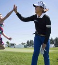 Lydia Ko, of New Zealand, gives a high-five to an enthusiastic young fan, four-year old Mackenzie Wilson after walking off the 11th hole during the pro-am at the Manulife LPGA Classic golf tournament in Cambridge, Ontario, Wednesday, June 3, 2015. (Peter Power/The Canadian Press via AP)