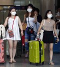Passengers flying from Seoul, South Korea, wear masks as a precaution against MERS, Middle East Respiratory Syndrome, as they arrive at Hong Kong Airport Tuesday, June 9, 2015.  The Hong Kong government on Tuesday issued a red travel alert for South Korea because of the current MERS outbreak in the country. (AP Photo/Kin Cheung)