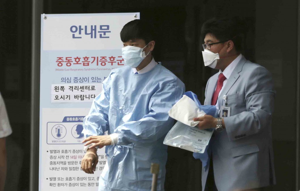 Hospital workers wearing masks walk past a precaution against the MERS, Middle East Respiratory Syndrome, virus near a quarantine tent for people who could be infected with the MERS virus at Seoul National University Hospital in Seoul, South Korea, Tuesday, June 2, 2015. South Korea on Tuesday confirmed the country's first two deaths from MERS as it fights to contain the spread of the virus that has killed hundreds of people in the Middle East. (AP Photo/Lee Jin-man)