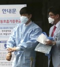 Hospital workers wearing masks walk past a precaution against the MERS, Middle East Respiratory Syndrome, virus near a quarantine tent for people who could be infected with the MERS virus at Seoul National University Hospital in Seoul, South Korea, Tuesday, June 2, 2015. South Korea on Tuesday confirmed the country's first two deaths from MERS as it fights to contain the spread of the virus that has killed hundreds of people in the Middle East. (AP Photo/Lee Jin-man)