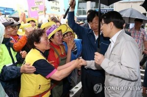 South Korean Prime Minister Hwang Kyo-ahn speaks with shop owners and visitors at a fish market in Seoul on June 26, 2015, as the government has struggled to keep the local economy afloat amid the outbreak of Middle East Respiratory Syndrome. (Yonhap)