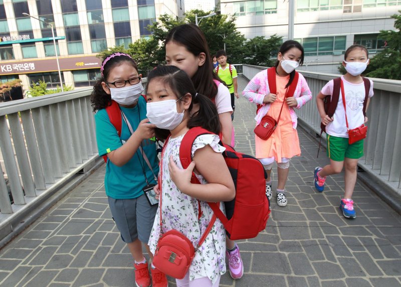 South Korean elementary school students wear masks as a precaution against the MERS, Middle East Respiratory Syndrome, virus as they go to school in Seoul, South Korea, Wednesday, June 10, 2015. South Korea believes its MERS virus outbreak may have peaked, and experts say the next several days will be critical to determining whether the government's belated efforts have successfully stymied a disease that has killed seven people and infected nearly 100 in the country.(AP Photo/Ahn Young-joon)