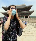 A Chinese tourist, wearing a facial mask, visits Gyeongbok Palace in Seoul on June 1, 2015, as South Korea confirmed three additional cases of the Middle East Respiratory Syndrome that day, raising the number of patients diagnosed with the illness to 18. (Yonhap)