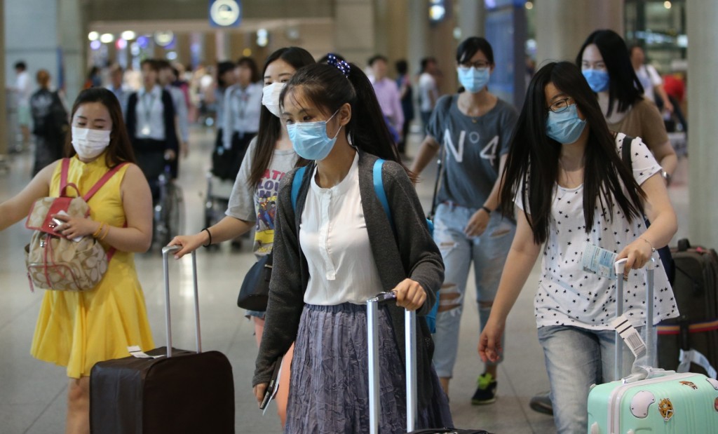 A group of foreign tourists wearing facial masks arrives at Incheon airport, west of Seoul, on June 2, 2015, as South Korea is gripped by increasing cases of the Middle East Respiratory Syndrome. The state-run Korea Tourism Organization said about 2,500 Chinese and Taiwanese tourists have called off their visits to South Korea as of June 1 due to the virus scare. (Yonhap)