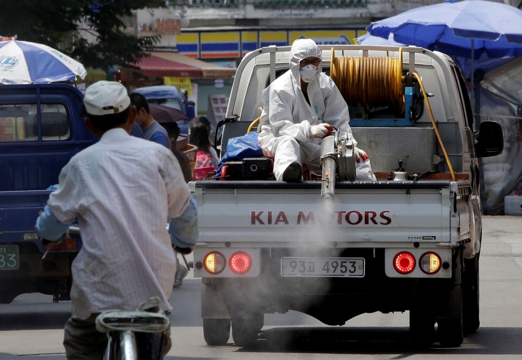 A worker wearing protective gears sitting on a truck sprays antiseptic solution as a precaution against the spread of Middle East Respiratory Syndrome (MERS) at a local market in Seoul, South Korea, Friday, June 12, 2015. South Korea’s economy is feeling the heat as the MERS outbreak slashed inflow of visitors and consumption. For a South Korean tour agency, the outbreak of a contagious disease turned out to be a bigger threat to the business than North Korean attack or nuclear fuel meltdowns. (AP Photo/Lee Jin-man)