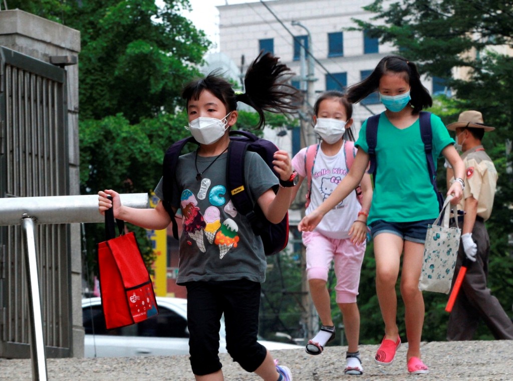 Elementary school students wear masks as a precaution against Middle East Respiratory Syndrome virus as they arrive at Midong Elementary School in Seoul, South Korea Monday, June 8, 2015. South Korea on Monday reported its sixth death from MERS as authorities were bolstering measures to stem the spread of the virus that has left dozens of people infected. (AP Photo/Ahn Young-joon)
