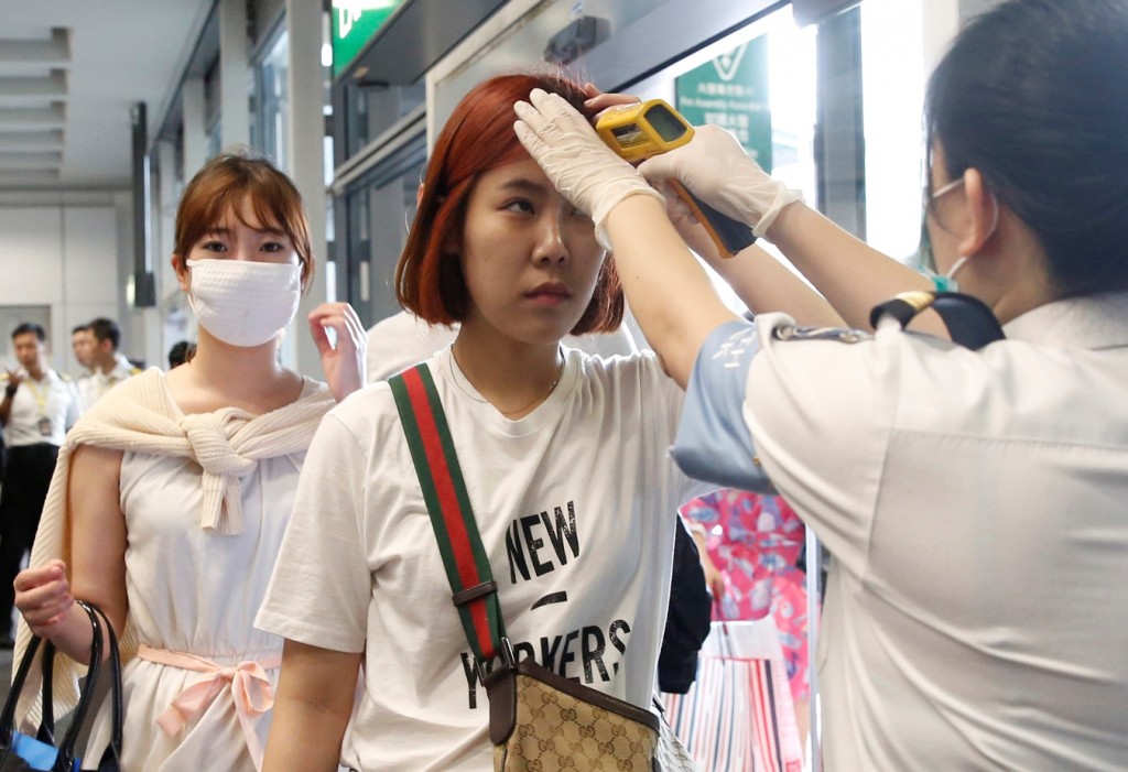 Passengers flying from Busan, South Korea, receive temperature checks for MERS (Middle East Respiratory Syndrome) as they arrive at Hong Kong Airport, Friday, June 5, 2015. The current frenzy in South Korea over MERS brings to mind the other menacing diseases to hit Asia over the last decade — SARS, which killed hundreds, and bird flu. (AP Photo/Kin Cheung)